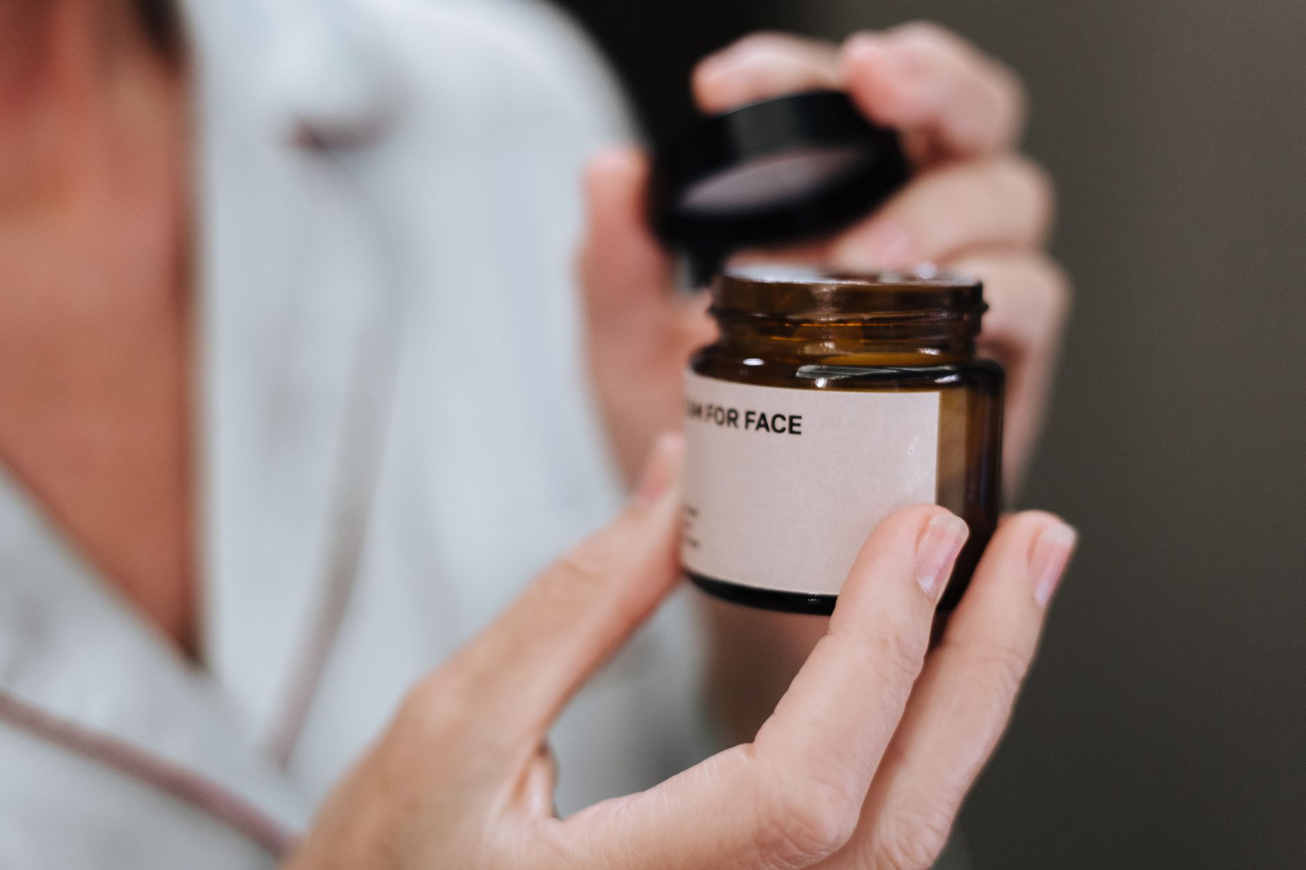 Close-up of a woman applying night cream to her face with a soft, glowing complexion.