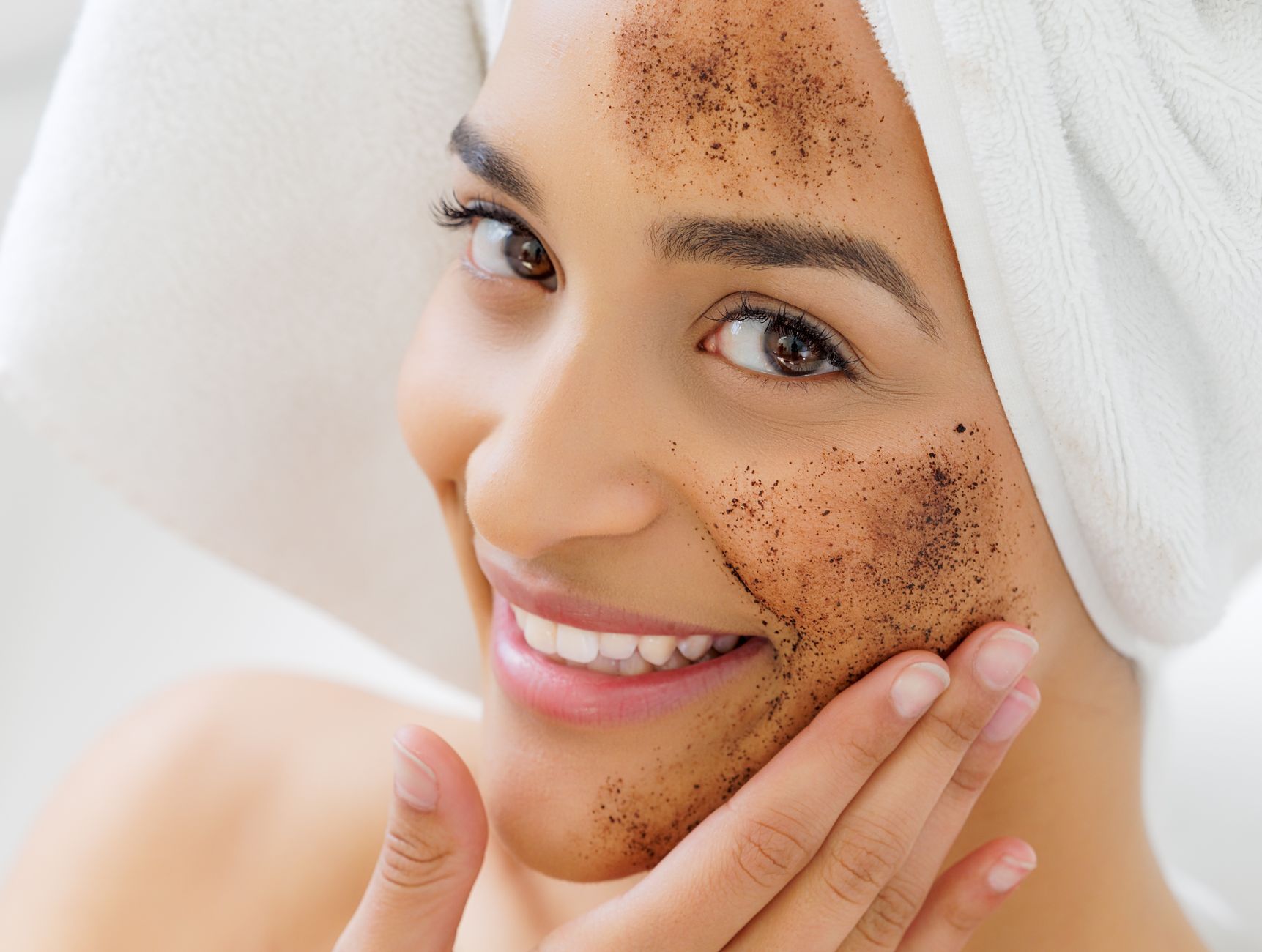 Close-up of a woman gently applying a serum to her face, representing chemical exfoliation for improved skin texture