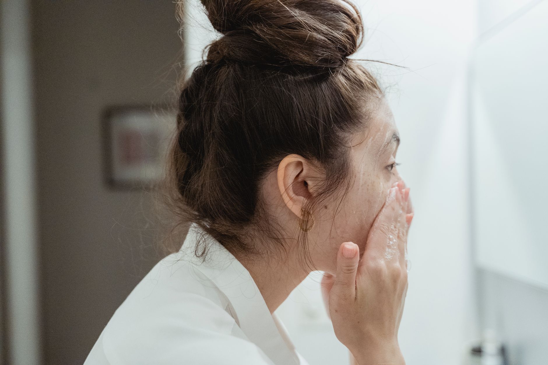 A woman gently washing her face with a gentle cleanser