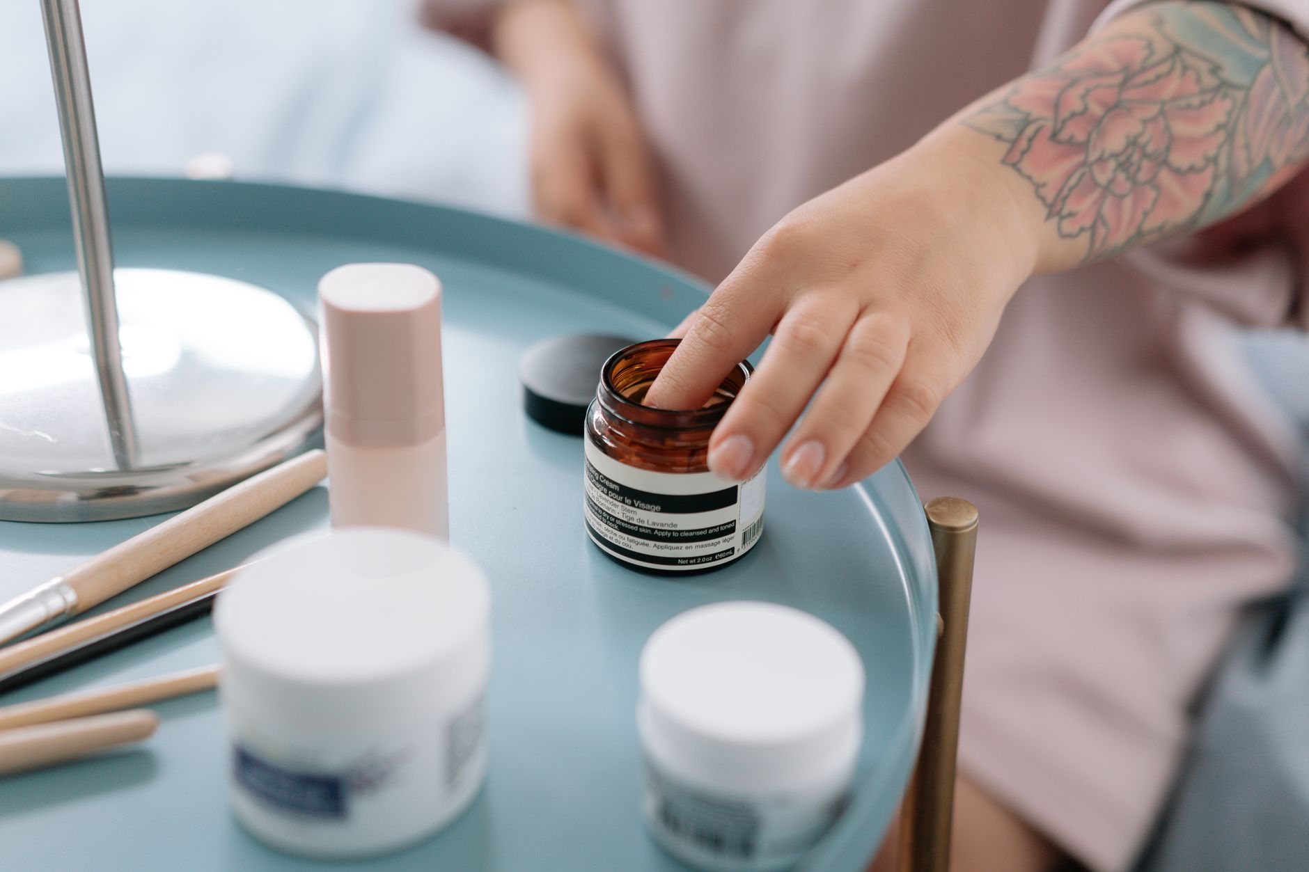 Woman applying skincare products in a well-lit bathroom